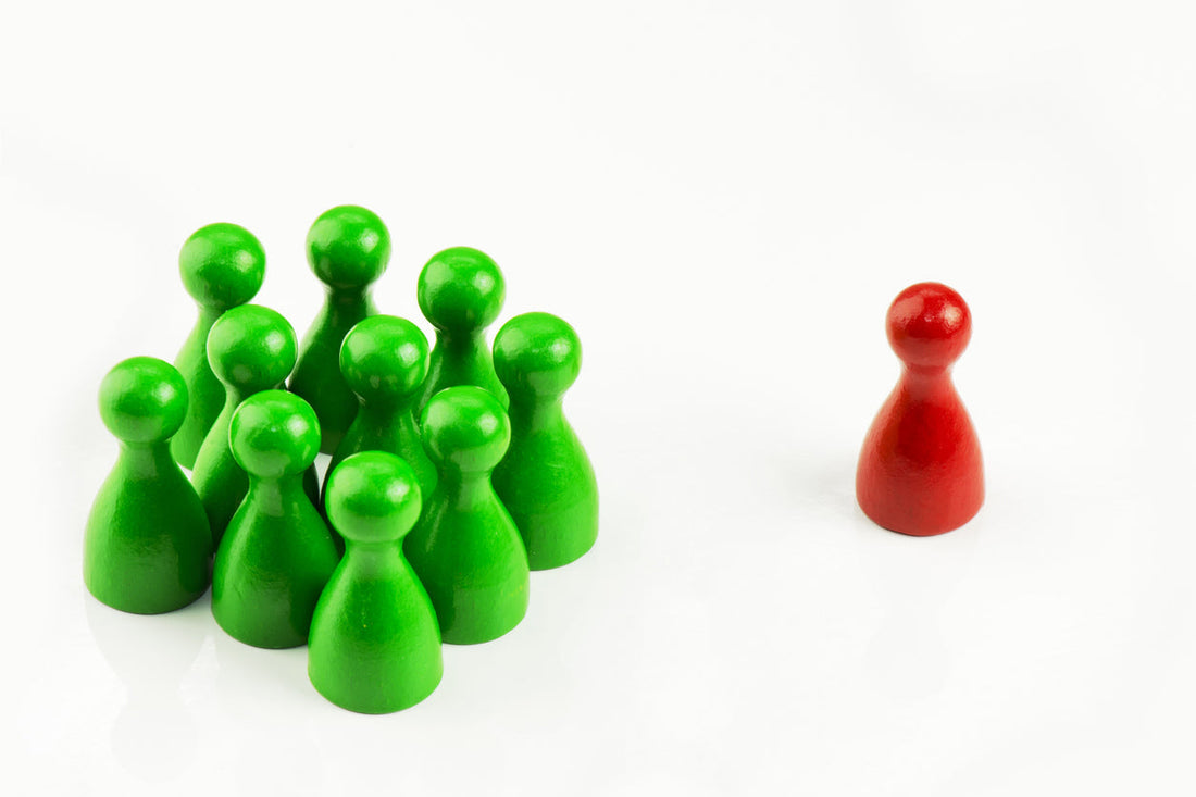 Spielfiguren in einer Gruppe mit sichtbarer Risikogruppe auf weissem Hintergrund