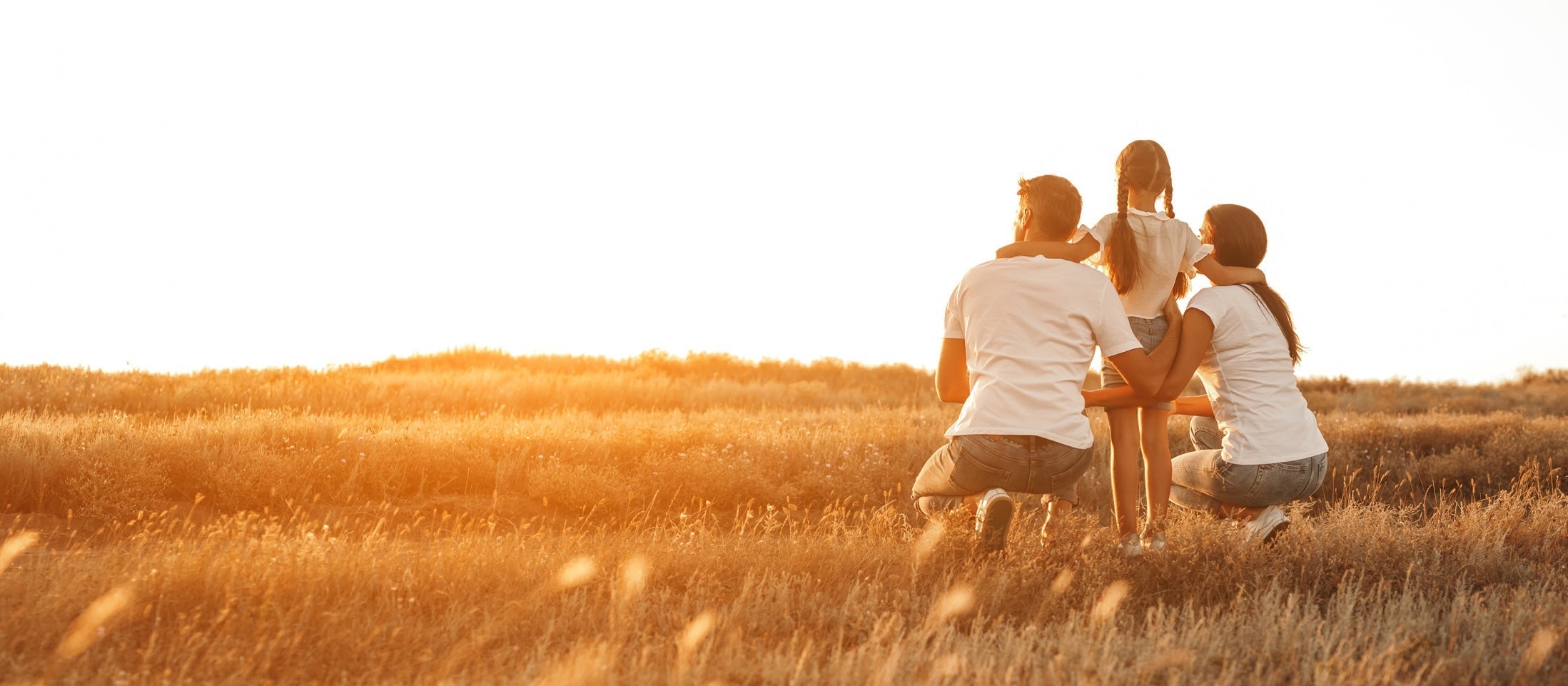Familie genießt Sonnenuntergang auf dem Land
